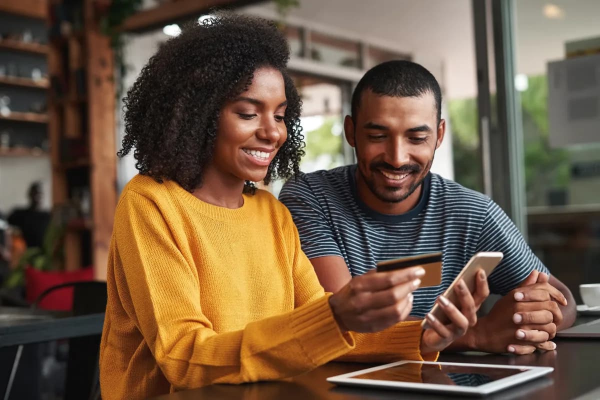 A couple comparing cash advance apps on a phone